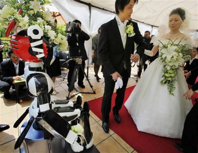 I-Fairy, a four-foot tall seated robot with flashing eyes and plastic pigtails, directs a wedding ceremony for groom Tomohiro Shibata 42, and bride Satoko Inouye, 36, at a Tokyo restaurant on Sunday.